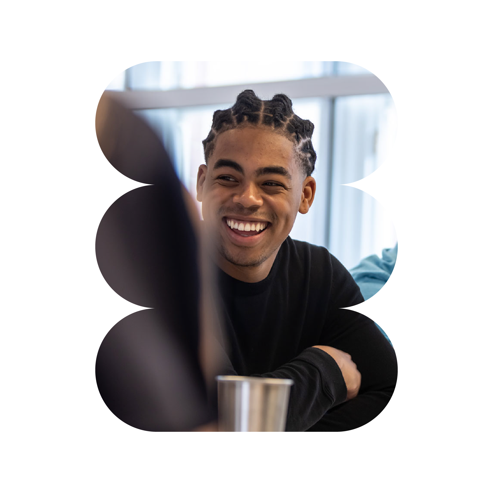 Smiling man in a black tshirt is leaning on a table