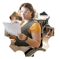 A female employee sits in a wheelchair and is reading a printed document