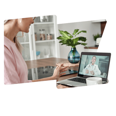 A woman in a pink jumper is on a video call at her kitchen counter. On the laptop there is a doctor in a white coat wearing a stethoscope around his neck.