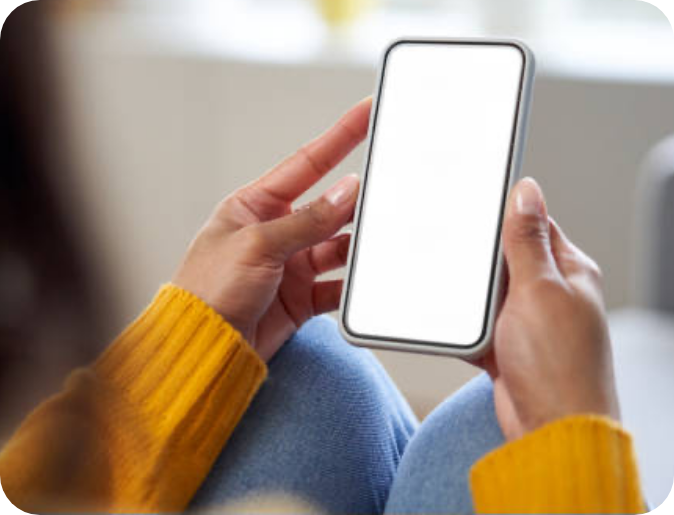 A person's hands are shown holding a smartphone over their lap