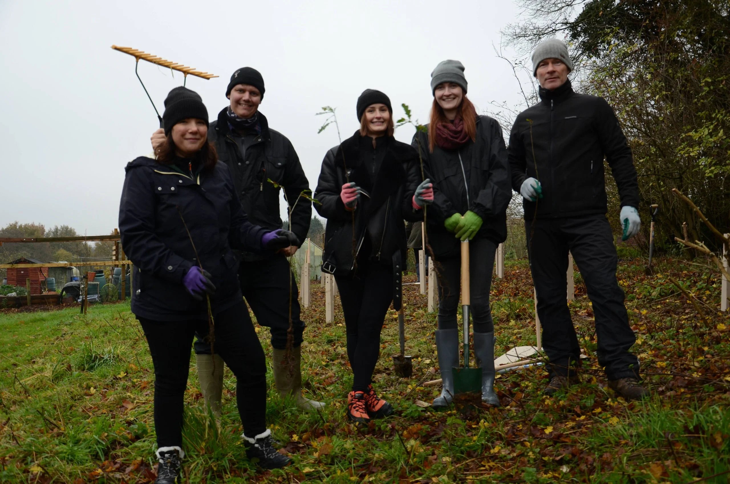 5 members of the Jobs Go Public team in a field with tree planting tools