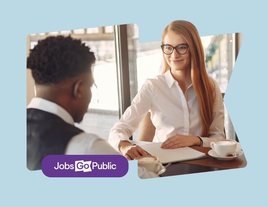 A man and a woman are dress in smart clothes, participating in a job interview across a table