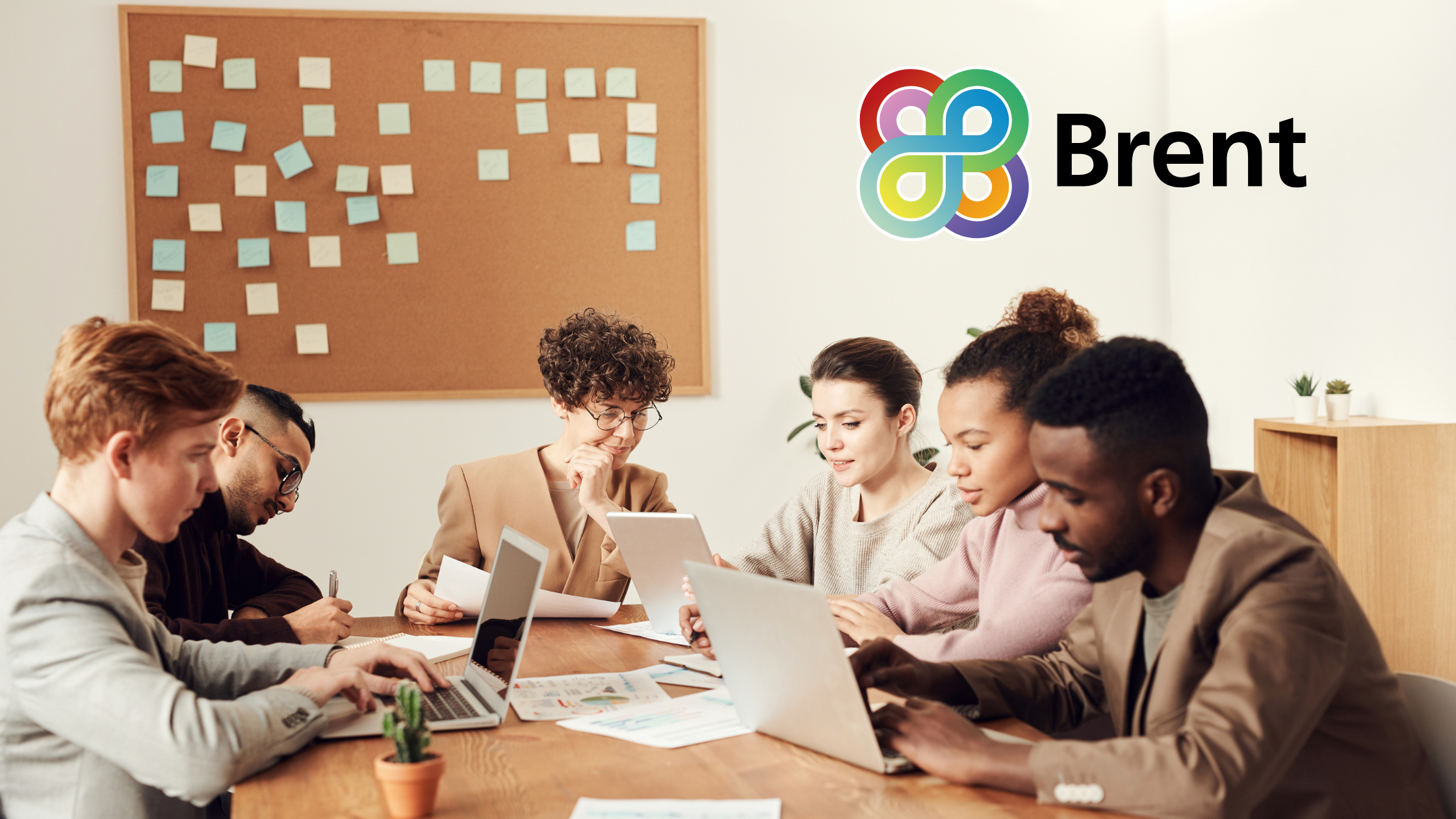 A team collaborating in a meeting room around a long wooden table, overlaid with the Brent logo